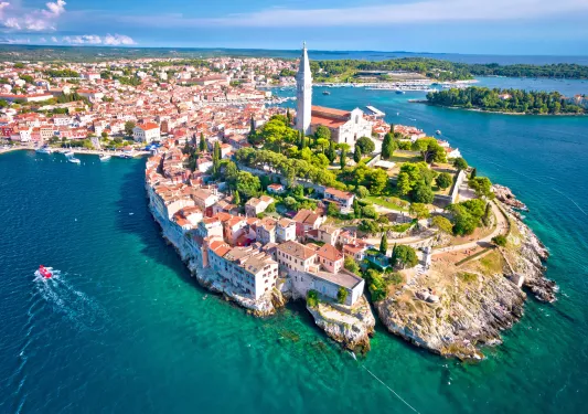 aerial view of an island with red roofed houses and greenery