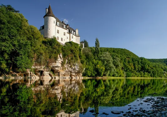 lakeside view of stone building on a cliff
