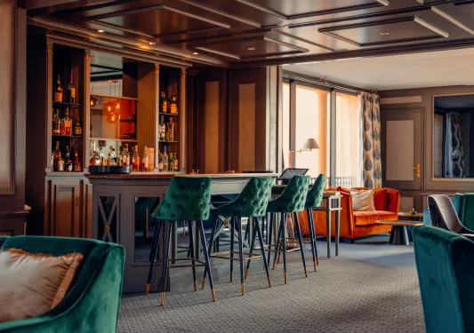 3 green chairs at a bar