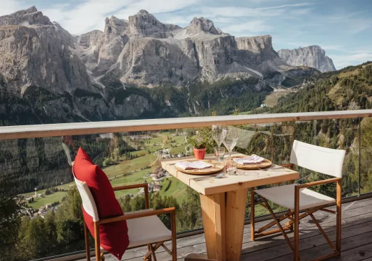 Two chairs with a dining table in the middle, looking out to large mountains