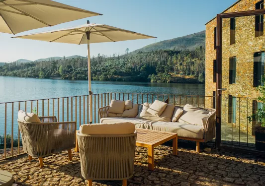 Couch and chairs under an umbrella on the balcony