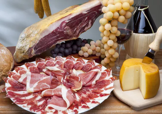 Plates full of cured meats, cheese and grapes