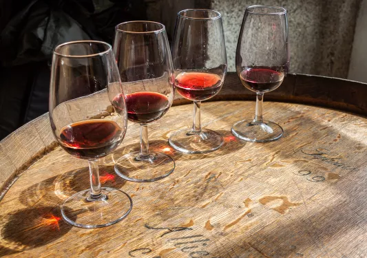Four glasses of wine on top of a barrell