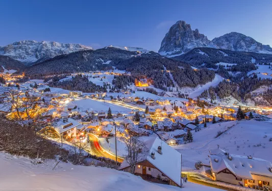 A small town covered in snow and lit up with lights