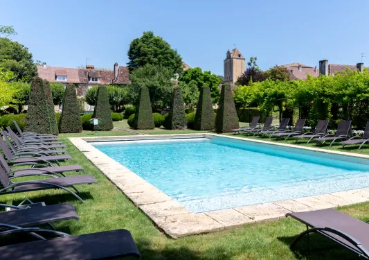 outdoor swimming pool surrounded by hedges