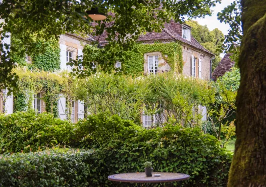 vines covering stone building and shrubs out front