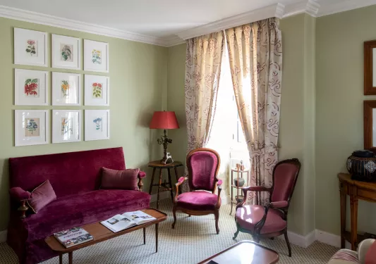 living room with red velvet furniture and framed picture frames