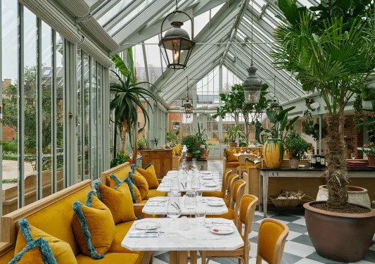 Indoor dining area with large open windows and orange couches