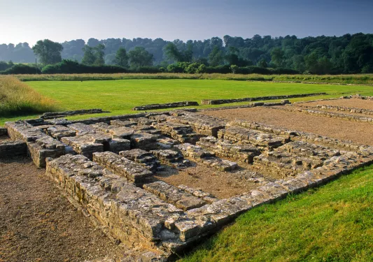 Remains of a brick building next to fields of grass
