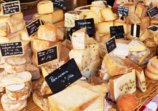 Market stand full of different cheeses with their prices on display