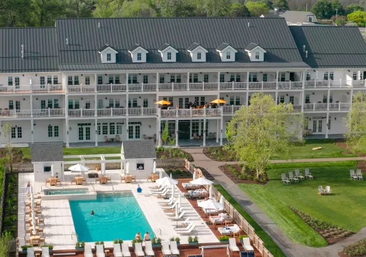Large, white building with outdoor balconies looking out to an outdoor pool