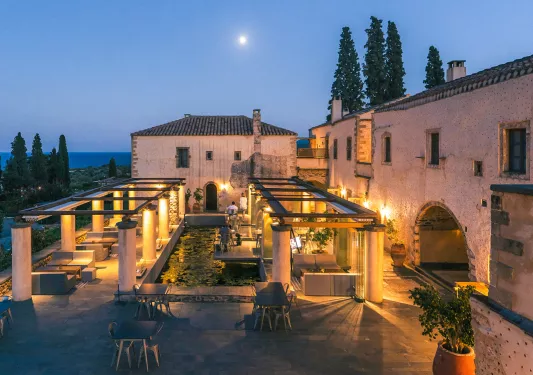 Outdoor lounge area with tall white pillars and orange lights