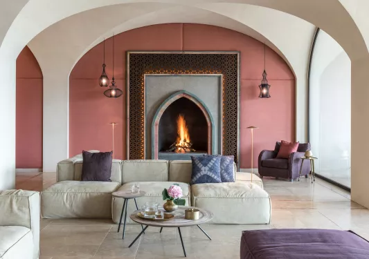 Indoor lounge with cushioned seats and a wood fireplace