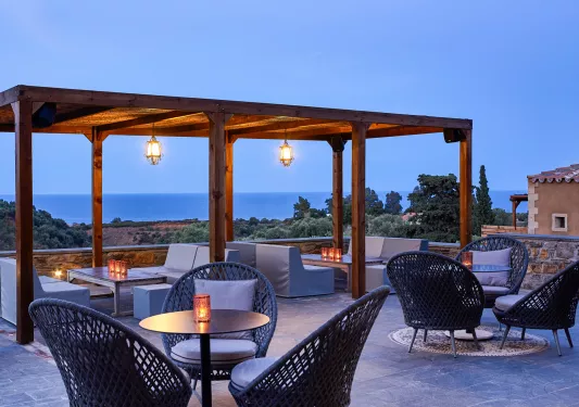 Outdoor lounge area with cushioned seats and wooden pillars