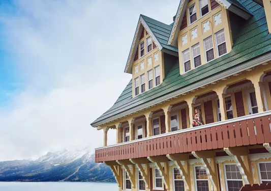 Large hotel building with an open balcony and a woman standing