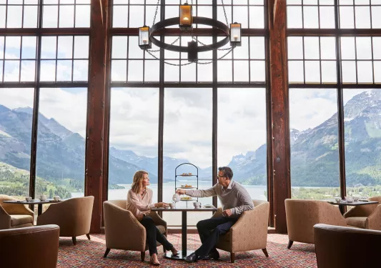 Man and woman in an open lounge sharing tea and pastries