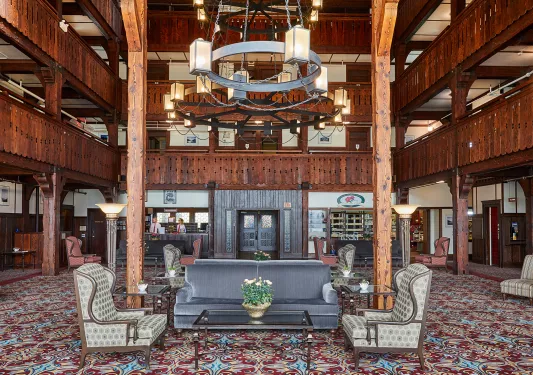 Indoor hotel lobby with cushioned seats and two concierges 