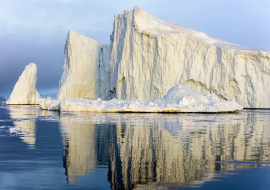 A large iceberg floating in blue water