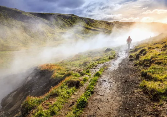 A person hikes through fog