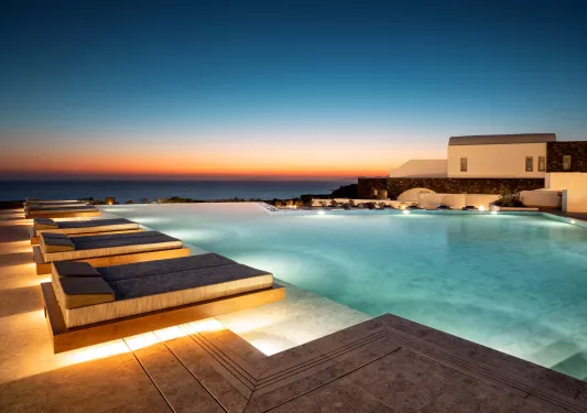 Outdoor infinity pool with beds along the perimeter