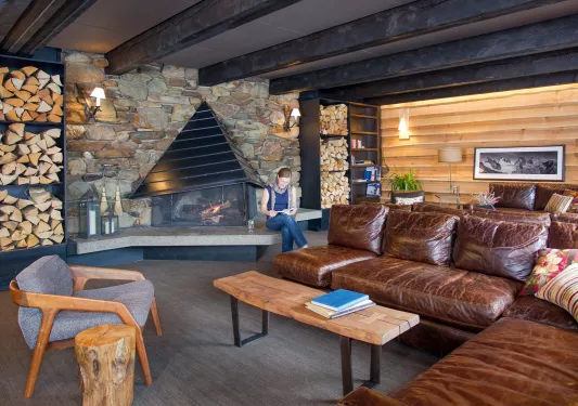 leather couches in front of stone fireplace