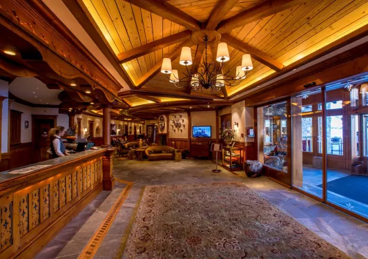 Hotel lobby with wooden furniture and a concierge at the desk