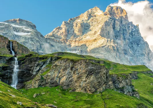 Grassy mountains in front of taller, foggy mountains