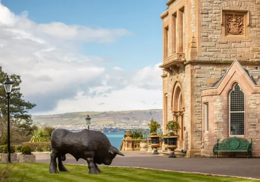 Buffalo statue outdoors next to a stone building