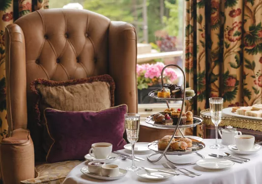 Leather couch with a white table full of pastries and tea