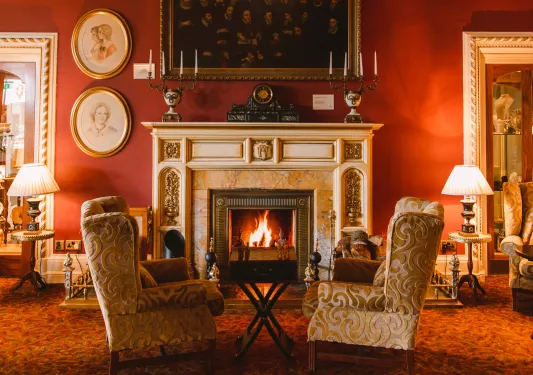 Two cushioned seats in front of a fireplace