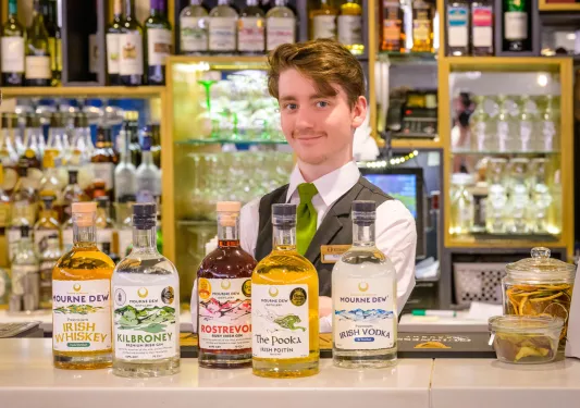 Bartender with multiple bottles of Irish whiskey on the counter