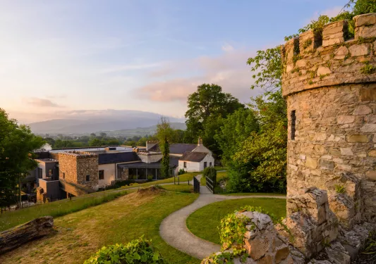 Castle-like building with a path leading towards a large hotel building