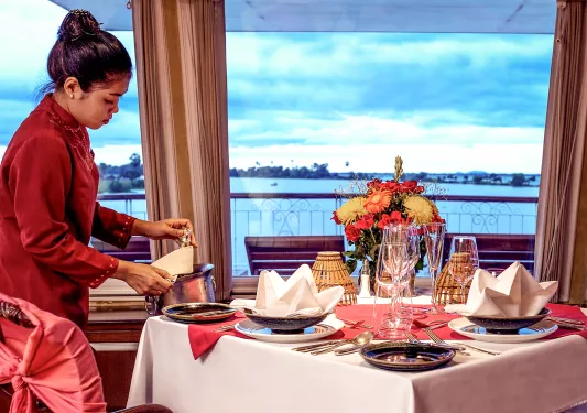 Woman in a red dress pulling out a bottle of wine from a chilled bucket