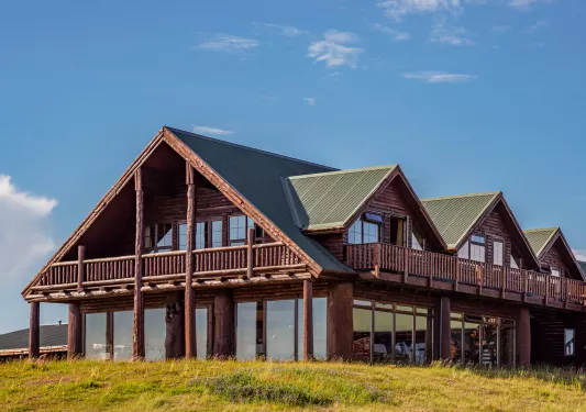 Outdoor view of wooden lodge with a green roof