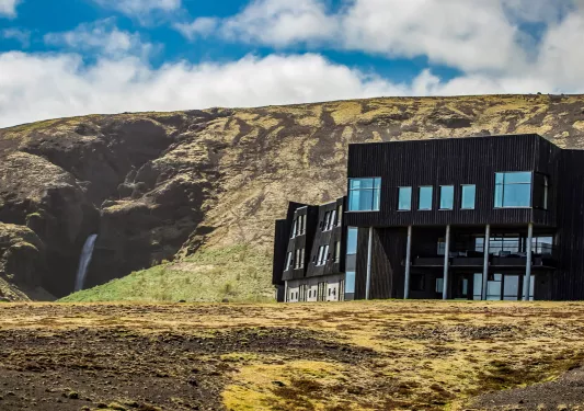 Black building with large, glass windows in the middle of a dried valley