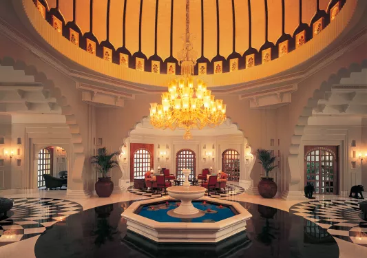 Large indoor lobby with a fountain and chandelier in the center