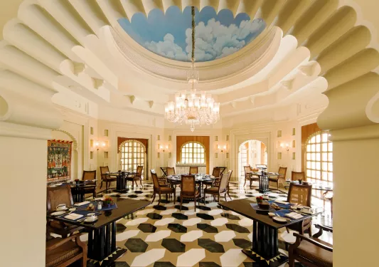 Indoor dining area with large ceilings and a chandelier