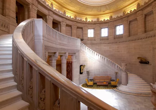 Indoor entrance with staircases on either side and couches on the ground floor