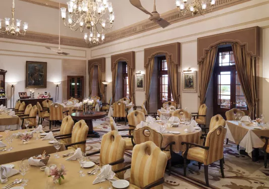 Indoor dining area with yellow striped cushioned chairs and wine glasses on the tables