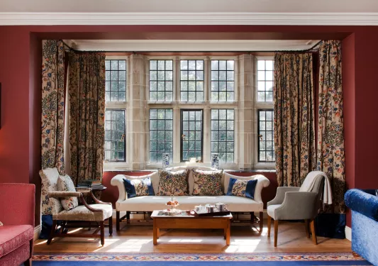 Sitting area with cushioned chairs and square pillows in front of large windows