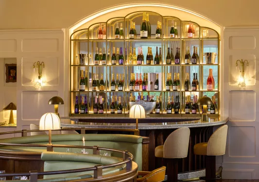 Crescent shaped bar with bottles of wine on the wall