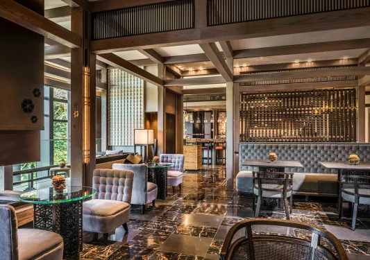 Indoor bar and lounge with marble floors and gray cushioned chairs