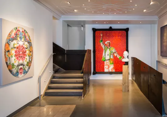 Lobby with a staircase on the right and large art pieces hanging on the wall