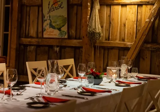 Indoor dining area with wooden walls and wine glasses on the tables