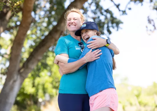 Two women hugging each other