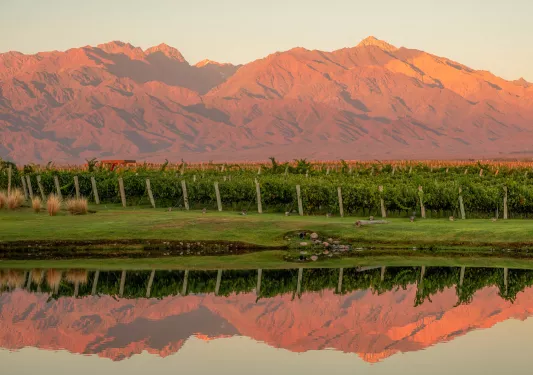 red mountain range reflected on water below it