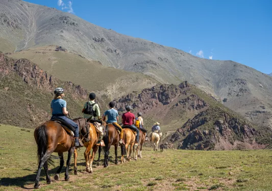 people horseback riding in the mountains