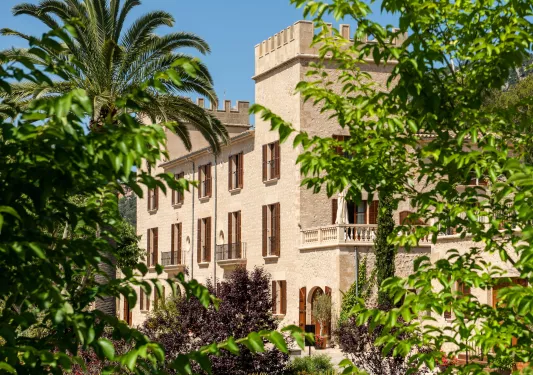 large stone building surrounded by lush greenery
