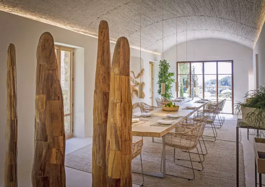 Indoor dining area with large, wooden art sculptures and large windows