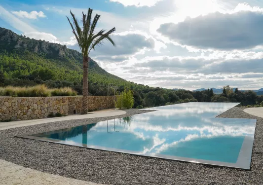 Outdoor infinity pool surrounded by stone and gravel